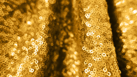 Holiday background from golden glitter sequins with depth of field. Metallic bright close up...