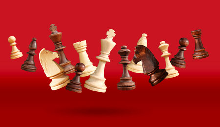 All the chess pieces floating or jumping on table. King, queen, bishop, knight, pawn, rook, floating on red background collage with white chess pieces. Advertising chess school. High quality photoの写真素材