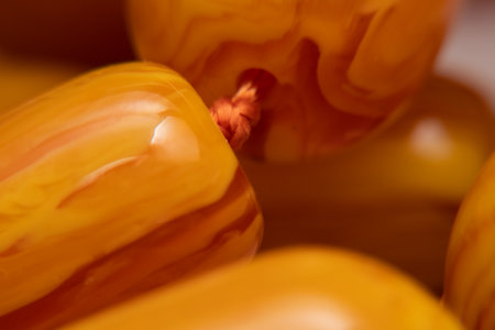 Macro close up Big yellow and orange round amber balls from the Baltic Sea. amber stone. Amber necklace. DOFの写真素材