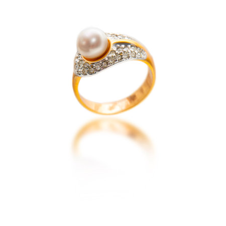 Closed up white pearl with diamond and gold ring isolated on whiteの写真素材