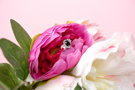 Wedding ring with a large dark blue sapphire in peonies. Wedding jewelry composition.の写真素材