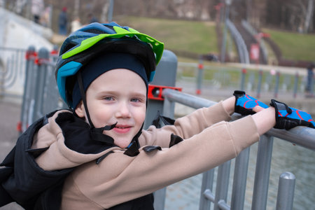 a little boy on a scooter in a protective helmet.Popular protect equipments for safety kids on street of city.の写真素材
