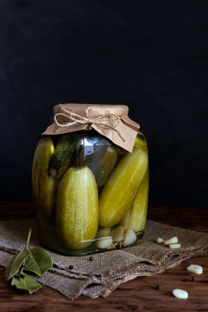 Canned vegetables in jars. Pickled cucumbers on a wooden table. Vertical orientation, copy spaceの写真素材