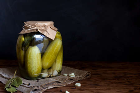 Fermented vegetables in jars. Pickled cucumbers on a wooden table. Horizontal orientation, copy spaceの写真素材