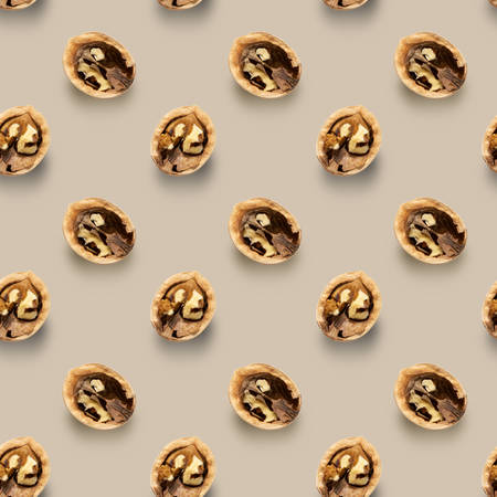 Seamless pattern with walnut halves on a beige background. Made from photoの写真素材