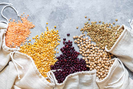 Various legumes in eco bag on gray backgroundの写真素材