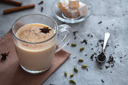 Masala chai with spices and milk in a transparent cupの写真素材
