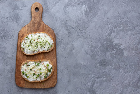 Two microgreen sandwiches on a cutting board on a grey background. Flat lay with copy spaceの写真素材