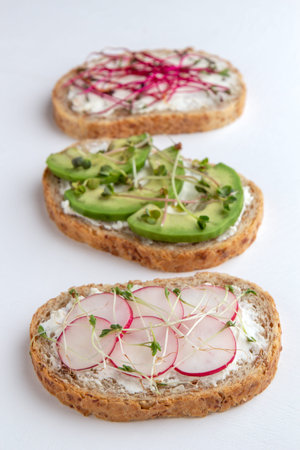 Three microgreen sandwiches on a white background. Close-up