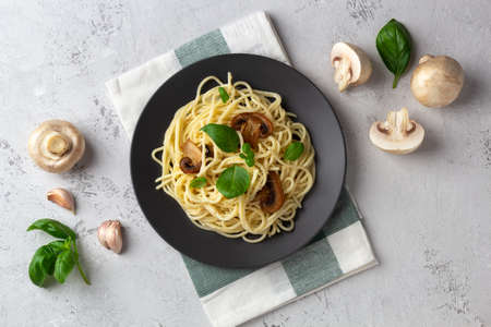 Spaghetti with mushrooms and cream sauce on a light background. Flat lay with ingredientsの写真素材