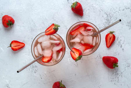 Two strawberry cocktails with ice on a light background with berries. View from aboveの写真素材