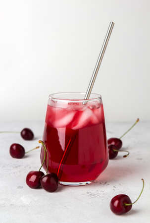 Cocktail with sweet cherry and ice on a light backgroundの写真素材