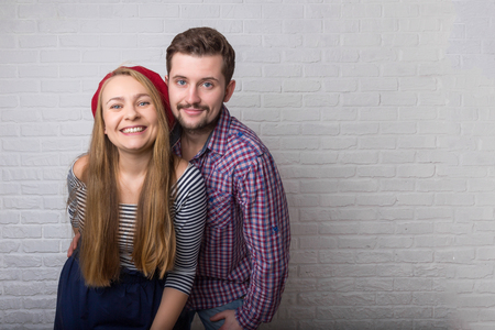 A happy funny couple in love enjoys Valentine's Day. A man with a beard and a woman with long blond hair and a red beret.の写真素材