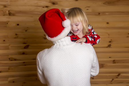 Father in the hat Nicholas (standing on the back), holding his tiny daughter on his hands. The girl smiles.の写真素材