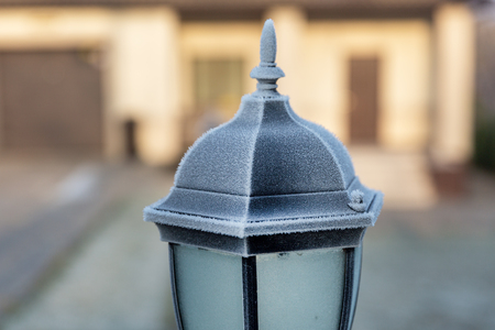 A black lighthouse near the house of the sun. First frost. Sunny weather. Copy space.の写真素材
