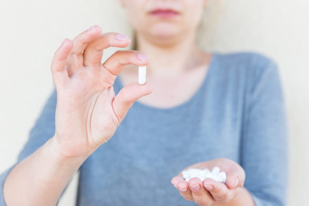 White tablets in female hands. Selective focus.