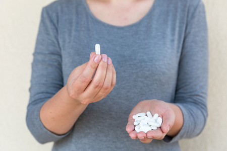White tablets in female hands. Selective focus.の写真素材