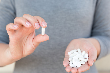 White tablets in female hands. Selective focus.の写真素材