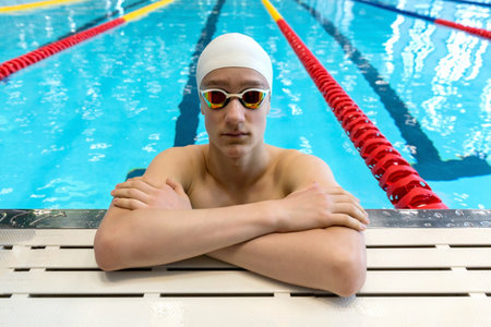 Portrait of a swimmer on the background of the pool. Pool background, copy space.