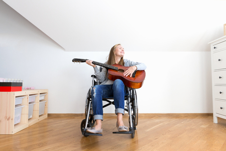 Young disabled woman playing the guitar.の写真素材