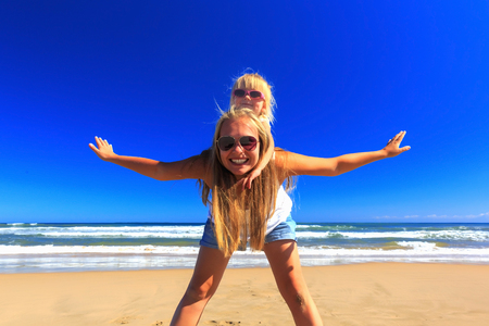 Happy mother and daughter spend their holidays on the seashore.の写真素材