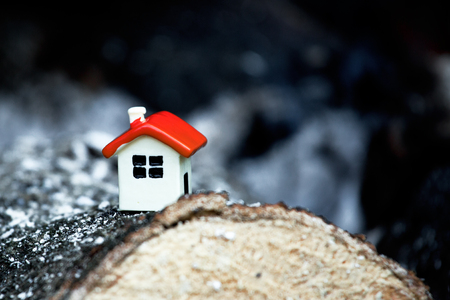 Small toy house lies on coals. Disaster concept.の写真素材