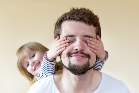 Cute little girl making surprise for her father.の写真素材