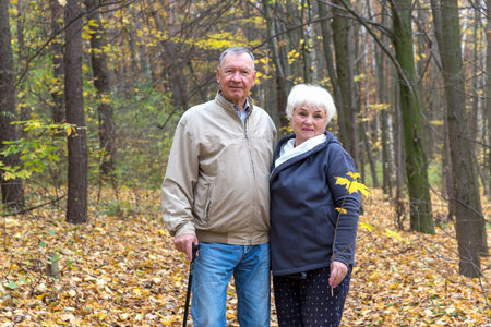 Happy elderly couple walking in an autumn parkの写真素材