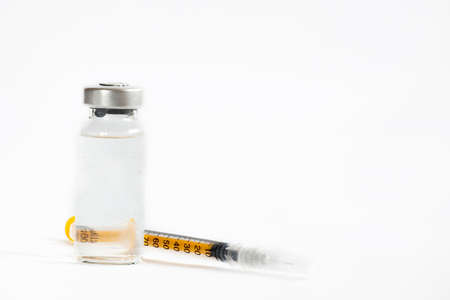 The vaccines vials glass bottle and disposable syringe on whiteの写真素材