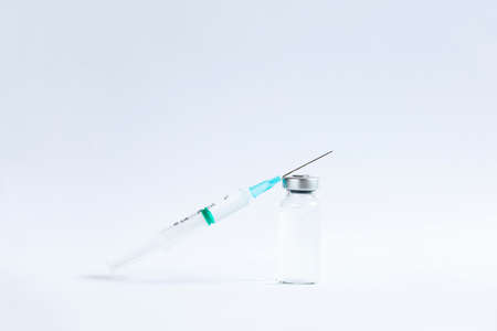 The vaccines vials glass bottle and disposable syringe on whiteの写真素材