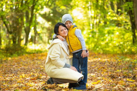 Happy Family! Mother and son have fun in autumn parkの写真素材