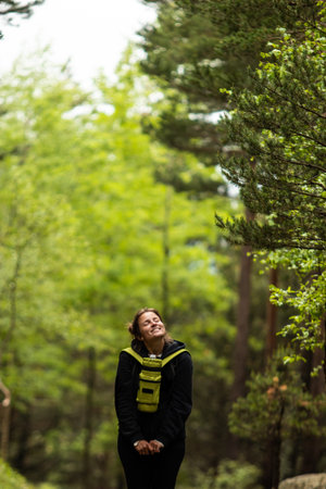 A tourist hike girl, during a walk in the forest of Pyrenees mountains of Andorra, near Encamp