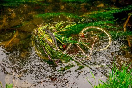 A sunken bicycle in shallow waters of river Don in Seaton park, Aberdeen city, Scotlandの写真素材