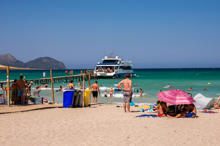 Tourists watch cruise ship arrival at Playa de Muro beach in Alcudia bay, Majorcaのeditorial素材
