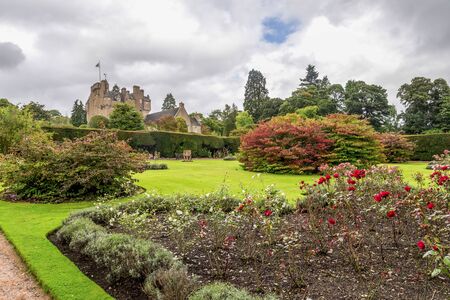 A view of Crathes Castle from a garden with a green lawn and several flower beds, Aberdeenshire, Scotlandのeditorial素材