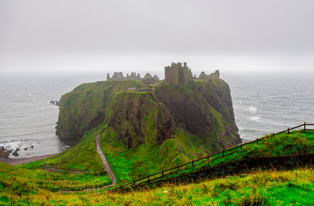 A view of famous tourist attraction Dunnotar Castle in poor Scottish autumn foggy weather, Aberdeenshire, Scotlandのeditorial素材