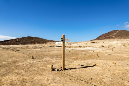 A wooden sign post to Mount Roja and Mount Bocinegro hiking tracks near El Medano town, Tenerife, Spainのeditorial素材