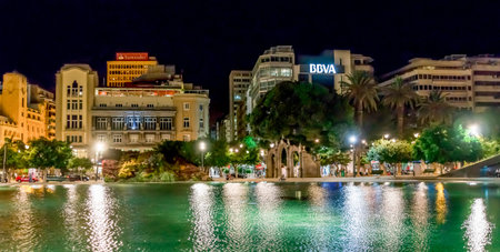 Spain Square at night with cityscape reflected in its water at the city centre of Santa Cruz de...