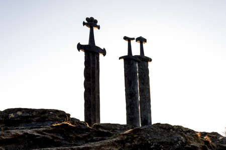 Three viking swords planted into ground on top of a rock at the sea shores of Hafrsfjord, Stavanger, Norway, February 2018. is unveiled by Norwegian King Olav in 1983. Sculptor â Fritz Roed (1928-2002)の写真素材