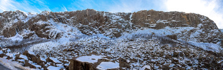 Panoramic view of Gloppedalsura geopark tourist landmark with natural quarry of house size rocks covered by snow near Byrkjedal, Norway, March 2018の写真素材