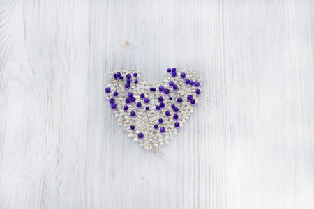 Hydrogel colorful balls in the form of a heart isolated on wooden background.