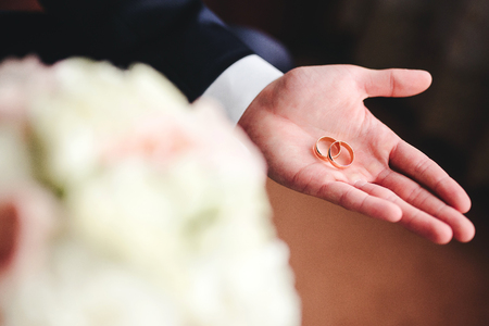 Gold wedding rings on groom's palmの写真素材