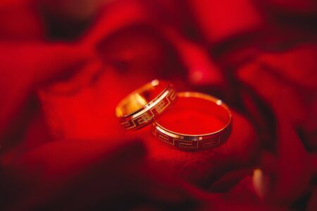Two Golden Wedding Rings on flowers macro shotの写真素材