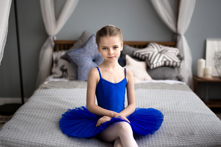 little ballerina sitting on a bedの写真素材