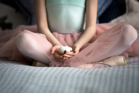 little ballerina sitting on a bedの写真素材