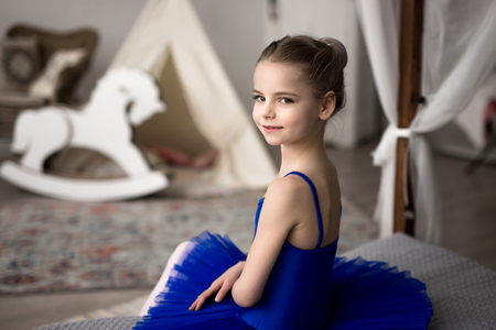 little ballerina sitting on a bedの写真素材
