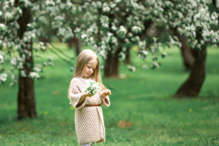 Little girl is walking in an apple gardenの写真素材