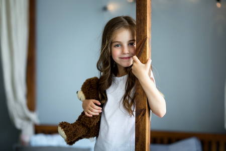 Portrait of a beautiful girl with a brown toy bearの写真素材