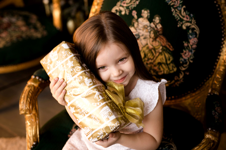 Happy little smiling girl with christmas gift box.の写真素材