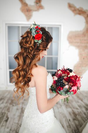Beautiful bride portrait with bright make-up sits on the bedの写真素材